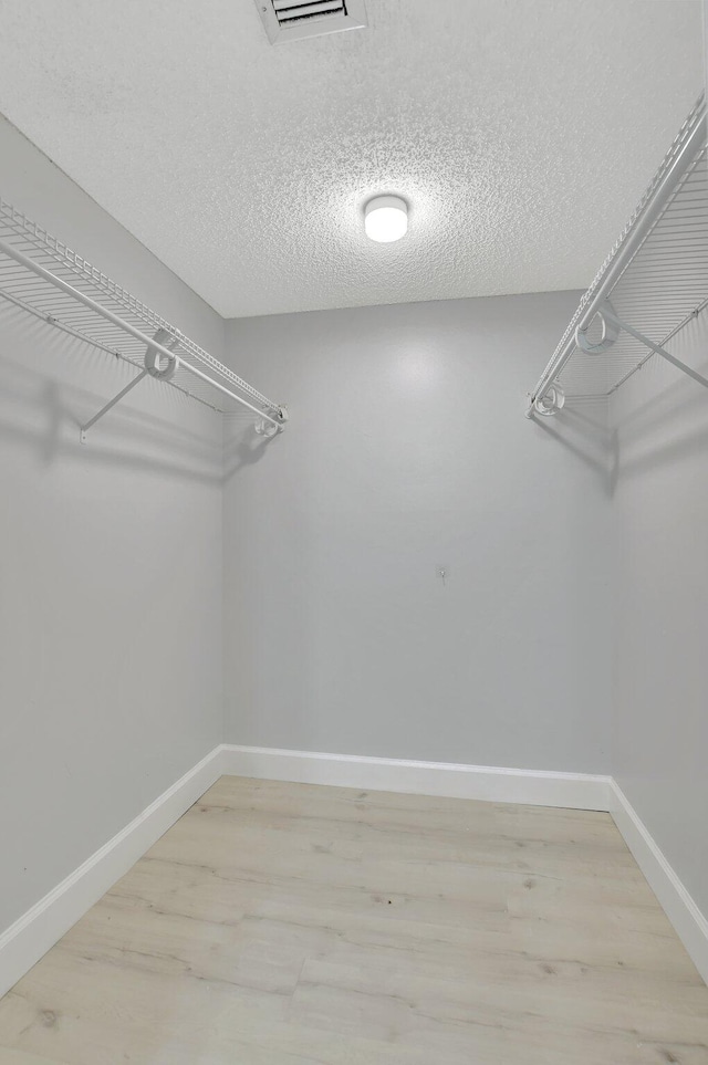 spacious closet with hardwood / wood-style floors