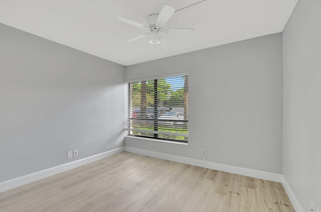 spare room with light wood-type flooring, a textured ceiling, and ceiling fan