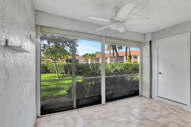 unfurnished sunroom with ceiling fan