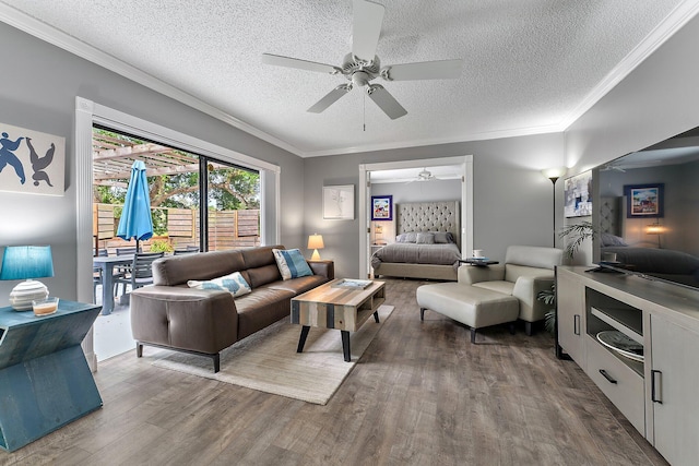 living area with wood finished floors, a ceiling fan, and crown molding