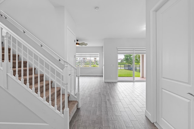 stairway with wood-type flooring and ceiling fan