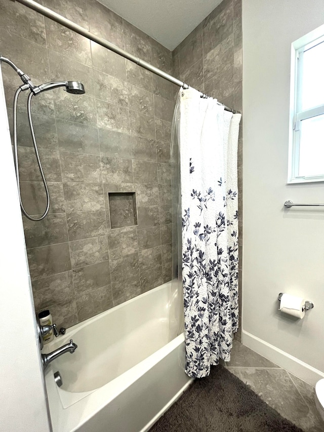 bathroom with shower / bath combo with shower curtain and tile patterned floors