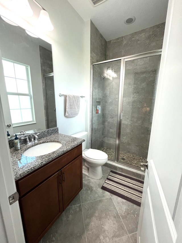 bathroom featuring tile patterned floors, walk in shower, vanity, and toilet