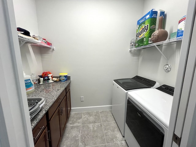 laundry area featuring light tile patterned flooring and washing machine and dryer