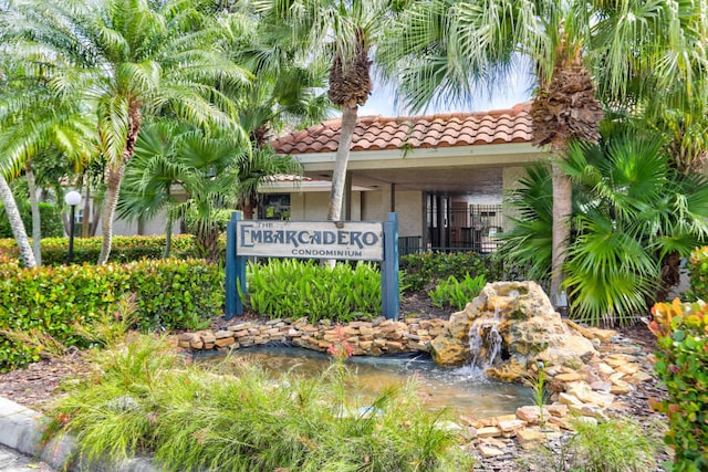 community / neighborhood sign featuring a garden pond