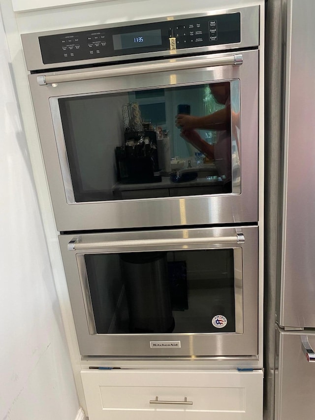 details featuring appliances with stainless steel finishes and white cabinets