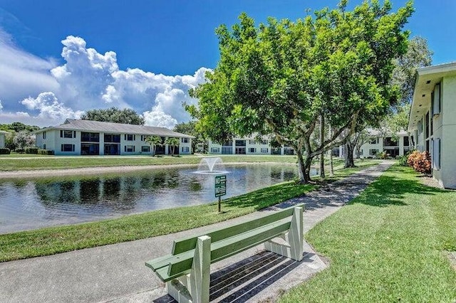 view of property's community featuring a water view and a yard