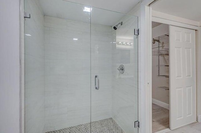 bathroom with a shower with door and hardwood / wood-style floors