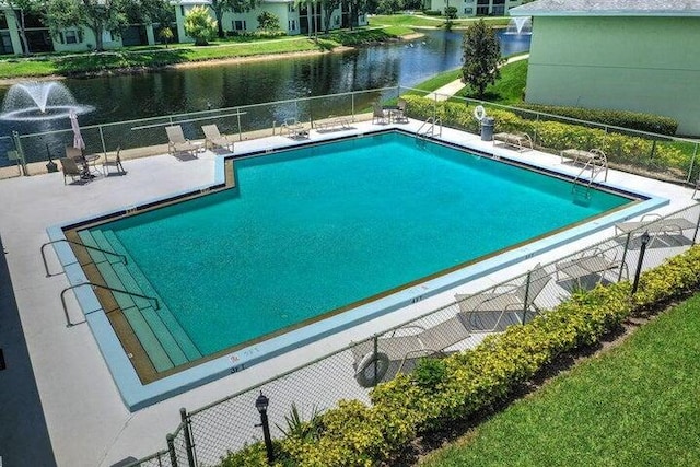 view of swimming pool with a water view and a patio area