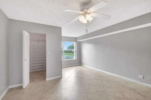 unfurnished bedroom with a closet, ceiling fan, and light tile patterned flooring