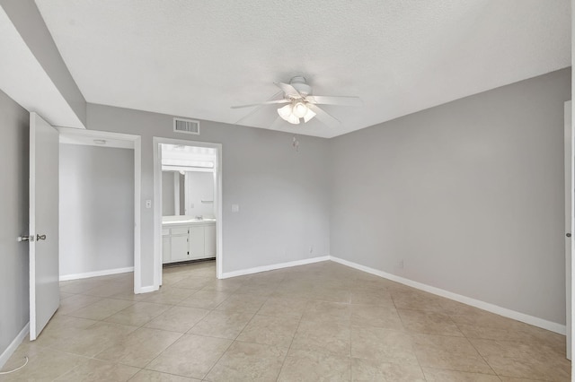 unfurnished bedroom with light tile patterned flooring, a textured ceiling, and ceiling fan