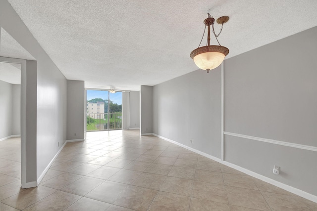 unfurnished room featuring floor to ceiling windows, a textured ceiling, and light tile patterned floors