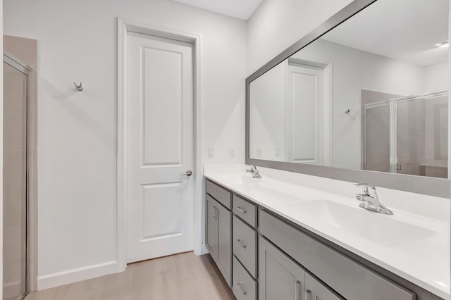 bathroom with hardwood / wood-style flooring, vanity, and an enclosed shower