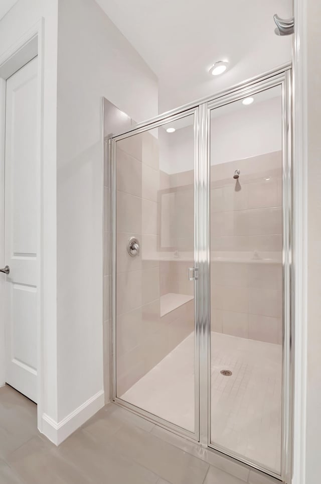 bathroom with tile patterned flooring and walk in shower