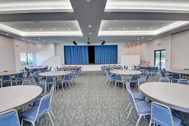 carpeted dining space featuring a tray ceiling and plenty of natural light