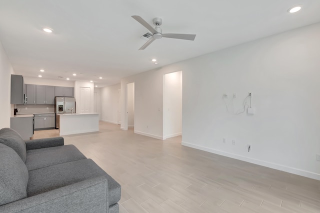 living room featuring ceiling fan and light hardwood / wood-style flooring