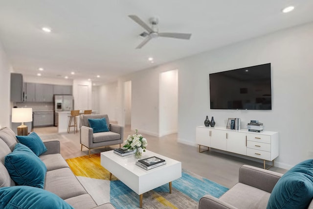 living room featuring light hardwood / wood-style floors and ceiling fan