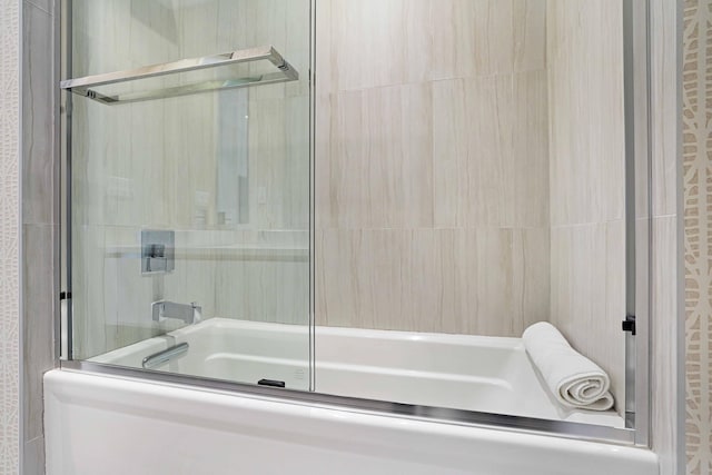 bathroom featuring combined bath / shower with glass door