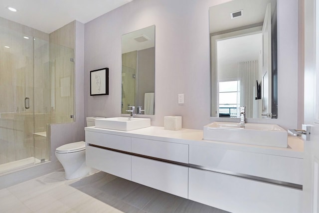 bathroom with vanity, toilet, and a shower with shower door