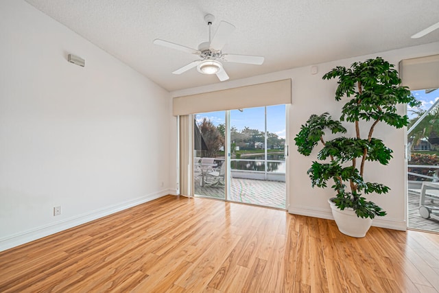 empty room with a textured ceiling, light wood-type flooring, and ceiling fan