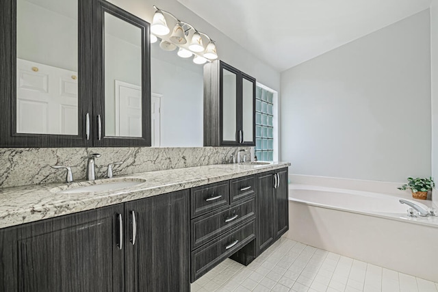 bathroom with vanity, a tub to relax in, tile patterned flooring, and vaulted ceiling