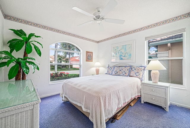 carpeted bedroom featuring a textured ceiling and ceiling fan