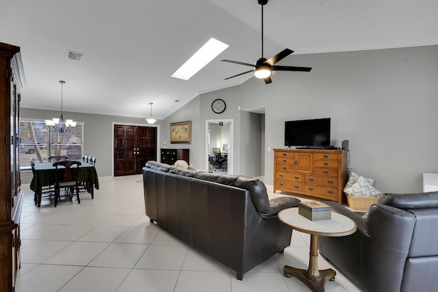 tiled living room with ornamental molding, lofted ceiling with skylight, and ceiling fan with notable chandelier