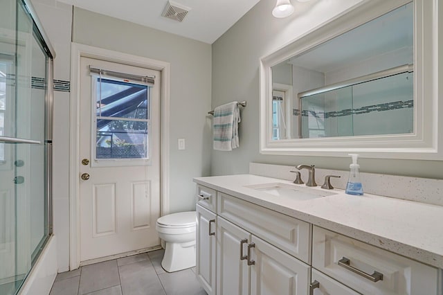 full bathroom featuring bath / shower combo with glass door, tile patterned floors, toilet, and vanity