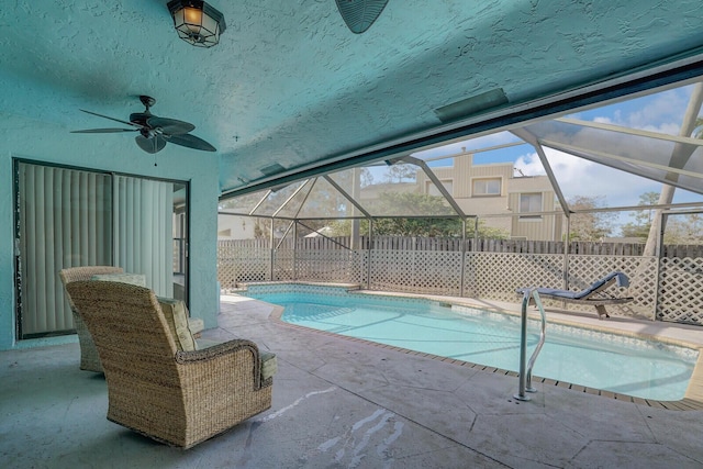 view of swimming pool featuring a lanai, ceiling fan, and a patio area