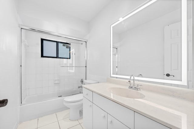 full bathroom with tile patterned flooring, tiled shower / bath combo, vanity, and toilet