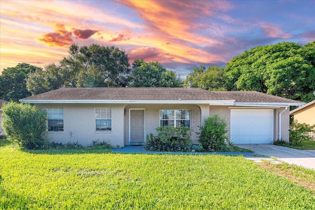 ranch-style house featuring a lawn and a garage