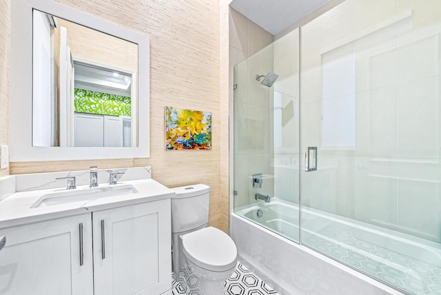 full bathroom with vanity, toilet, and bath / shower combo with glass door