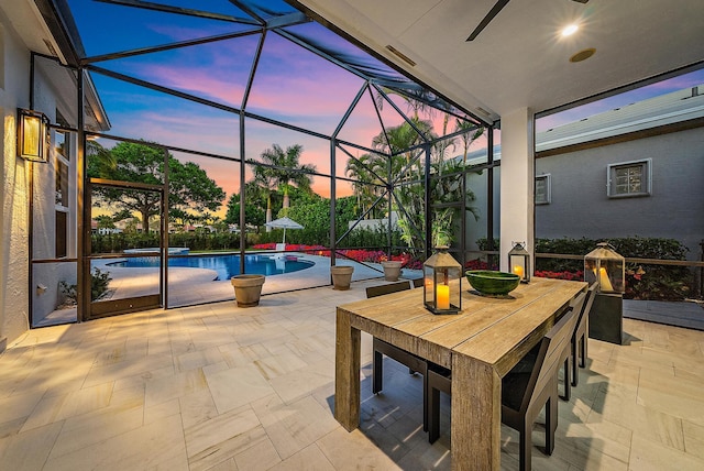 patio terrace at dusk featuring glass enclosure