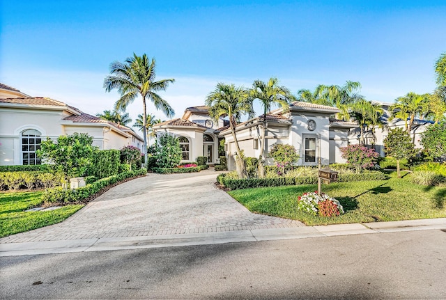 mediterranean / spanish home featuring a front lawn