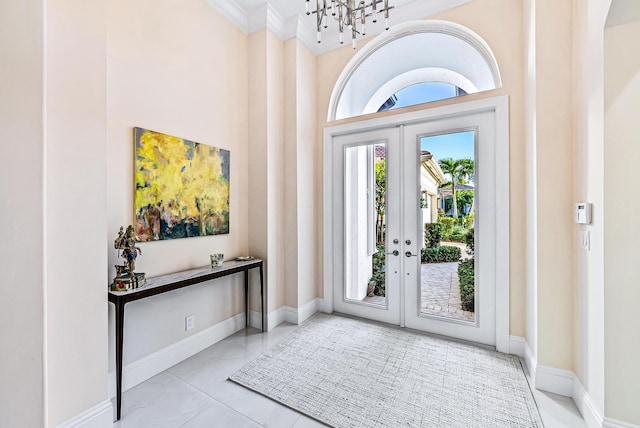 entrance foyer featuring french doors, crown molding, and a healthy amount of sunlight