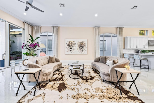 living room with ceiling fan, a healthy amount of sunlight, and ornamental molding