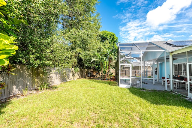 view of yard featuring a patio area, a lanai, and ceiling fan