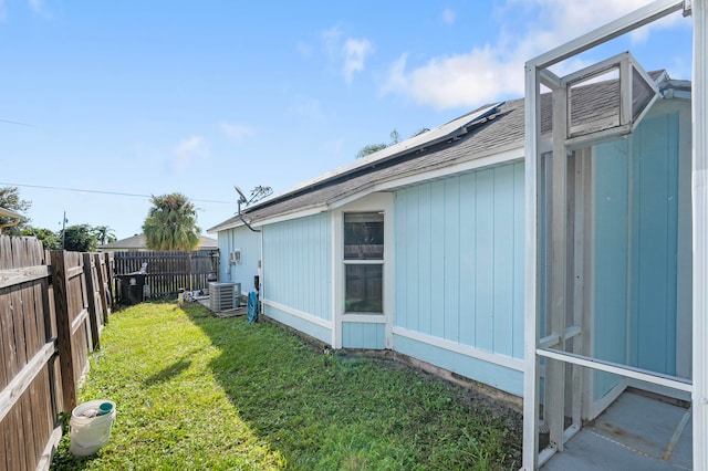 view of side of home with a yard and cooling unit