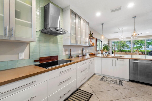 kitchen featuring dishwasher, white cabinetry, black electric cooktop, decorative light fixtures, and wall chimney exhaust hood