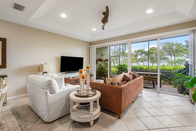 living room featuring light tile patterned floors and a raised ceiling