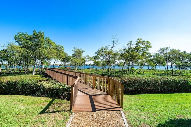 view of home's community featuring a lawn and a water view