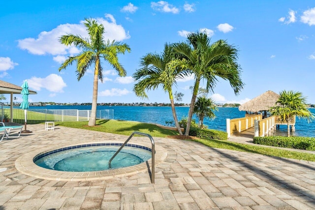 view of swimming pool featuring a patio area, a community hot tub, and a water view