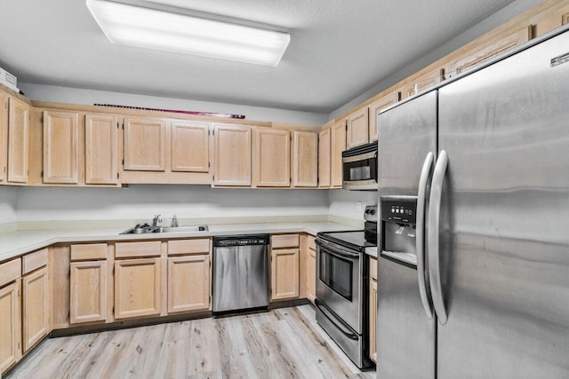 kitchen featuring light brown cabinetry, sink, light hardwood / wood-style flooring, and stainless steel appliances