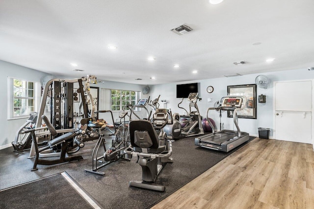 workout area featuring hardwood / wood-style floors and a textured ceiling