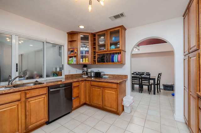 kitchen with dishwasher, stone countertops, light tile patterned flooring, and sink