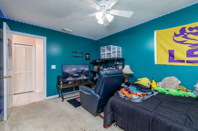 bedroom with ceiling fan, a textured ceiling, and carpet