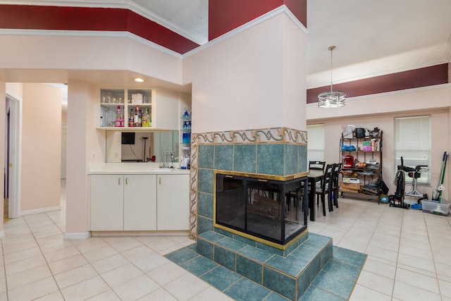 living room featuring ornamental molding, light tile patterned flooring, and sink