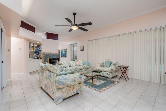 tiled living room with a tile fireplace, ornamental molding, and ceiling fan