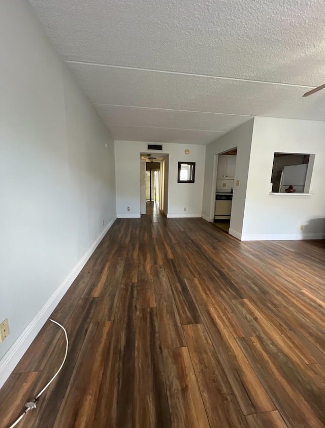 unfurnished living room with ceiling fan, a textured ceiling, and dark hardwood / wood-style floors