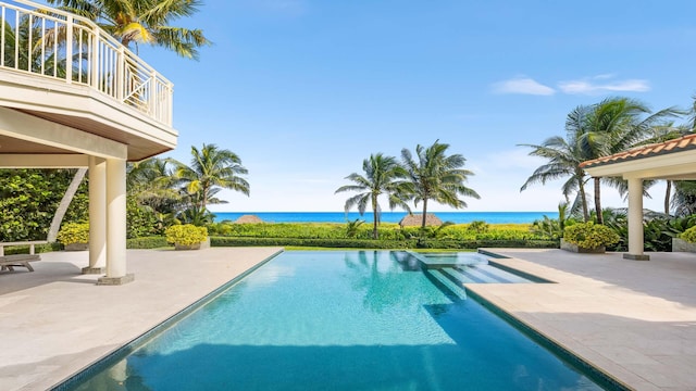 view of pool featuring a water view and a patio